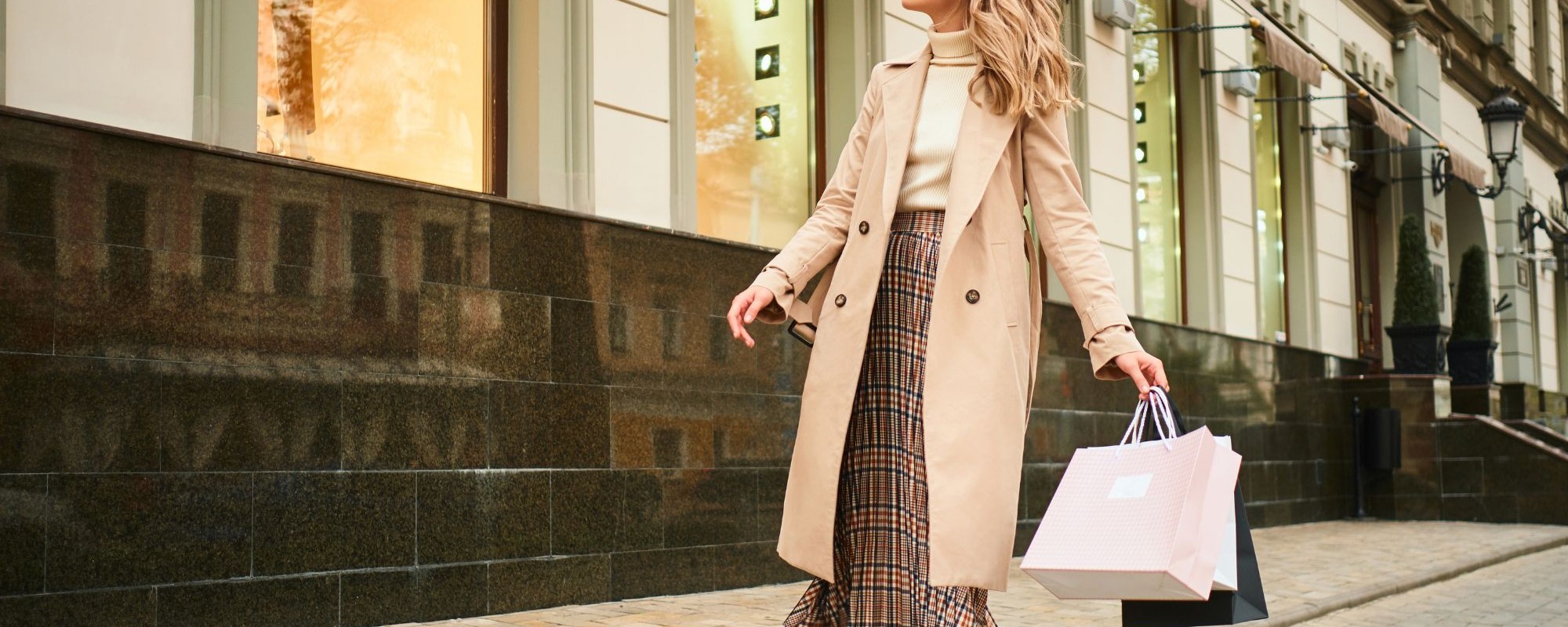 attractive-stylish-blond-girl-beige-coat-with-shopping-bags-dreamily-looking-store-window-walking-city-street