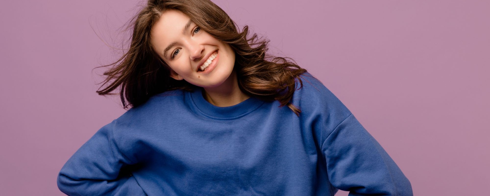 photo-pretty-fairskinned-young-girl-looking-camera-with-smile-her-face-purple-background-stylish-woman-having-good-time