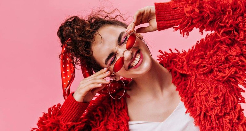 zabawna-kobieta-w-czerwonej-puszystej-kurtce-smiejac-sie-na-rozowym-tle